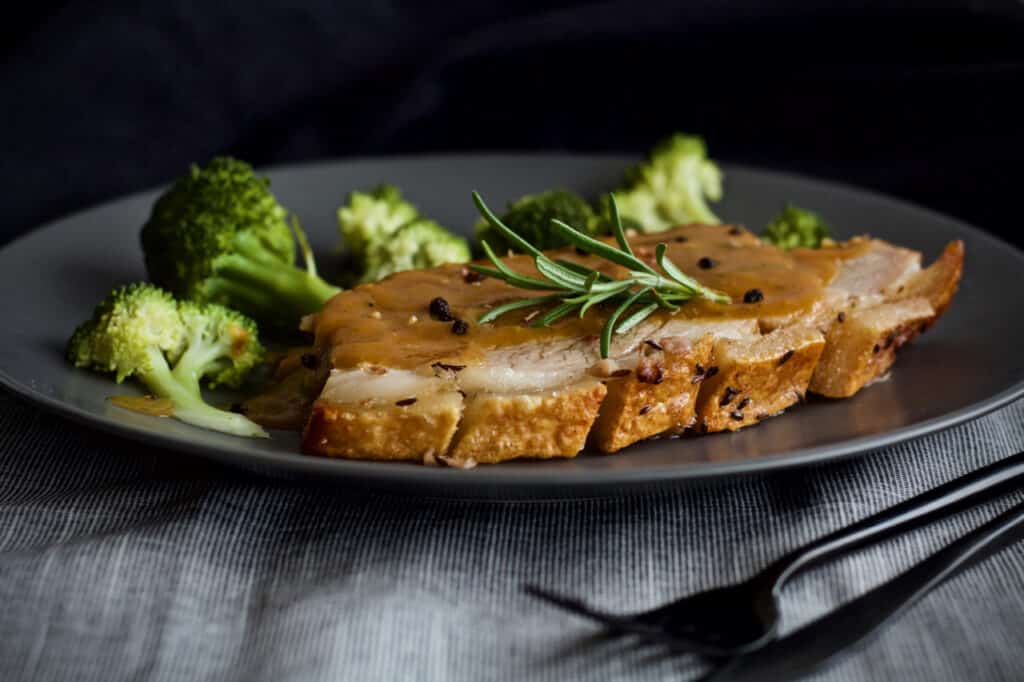Knuspriger Schweinsbraten mit Bratensauce und Brokkoli