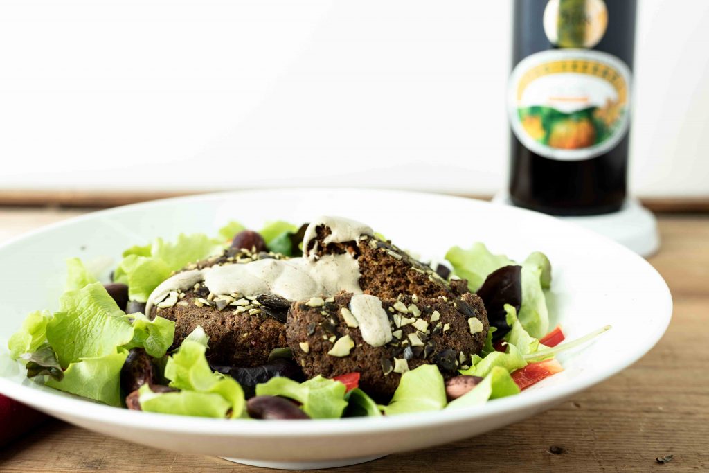 Käferbohnen Laibchen auf Salat mit Kürbiskernöl-Sauerrahm Dressing